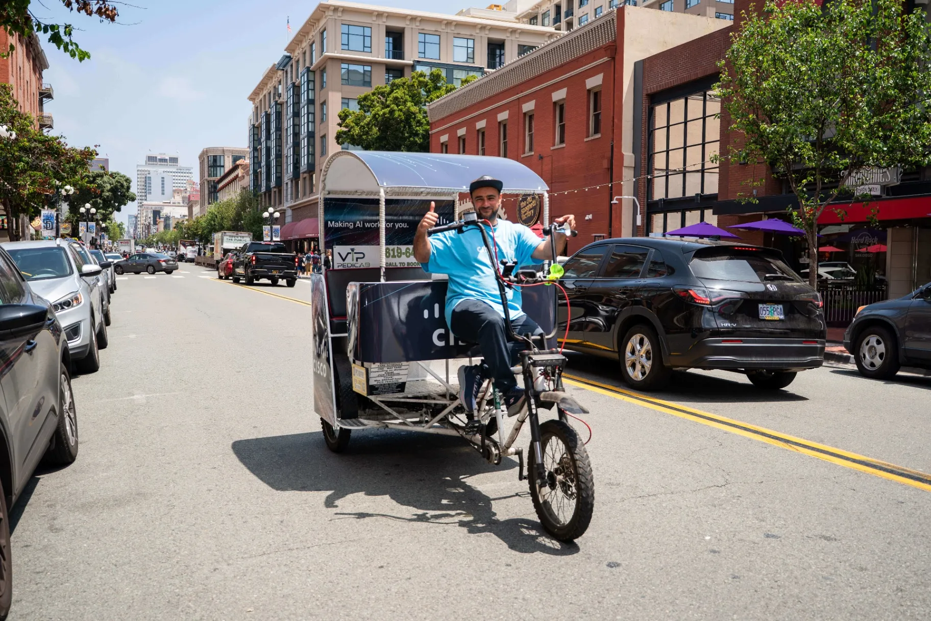 VIP Pedicab driver giving thumbs up on Cisco branded electric pedicab in San Diego