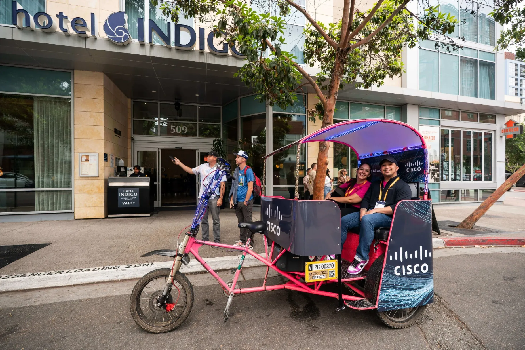 Cisco branded pedicab passengers being dropped off outside Hotel Indigo San Diego during convention