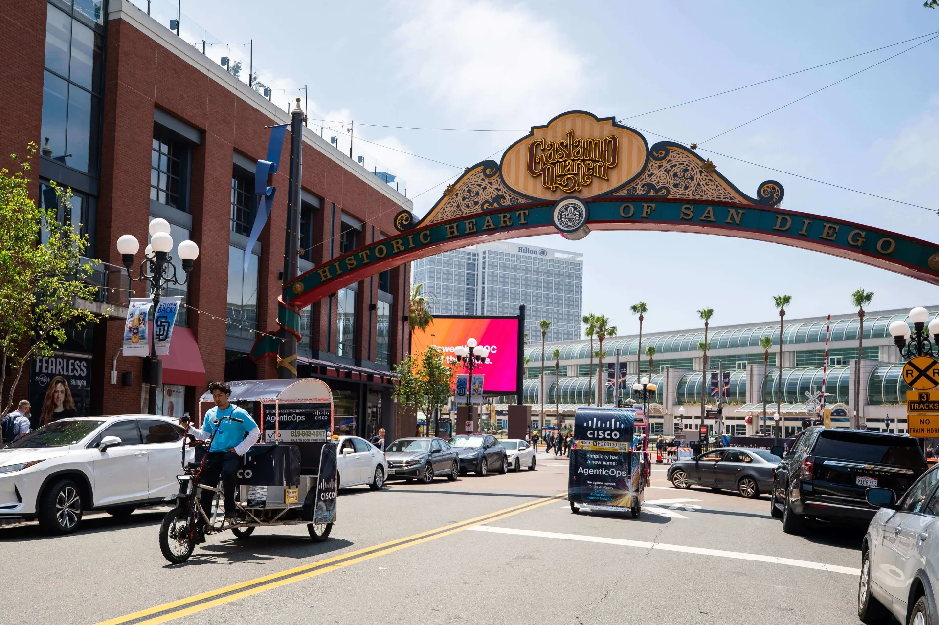 Cisco pedicab fleet passing under Gaslamp Quarter sign