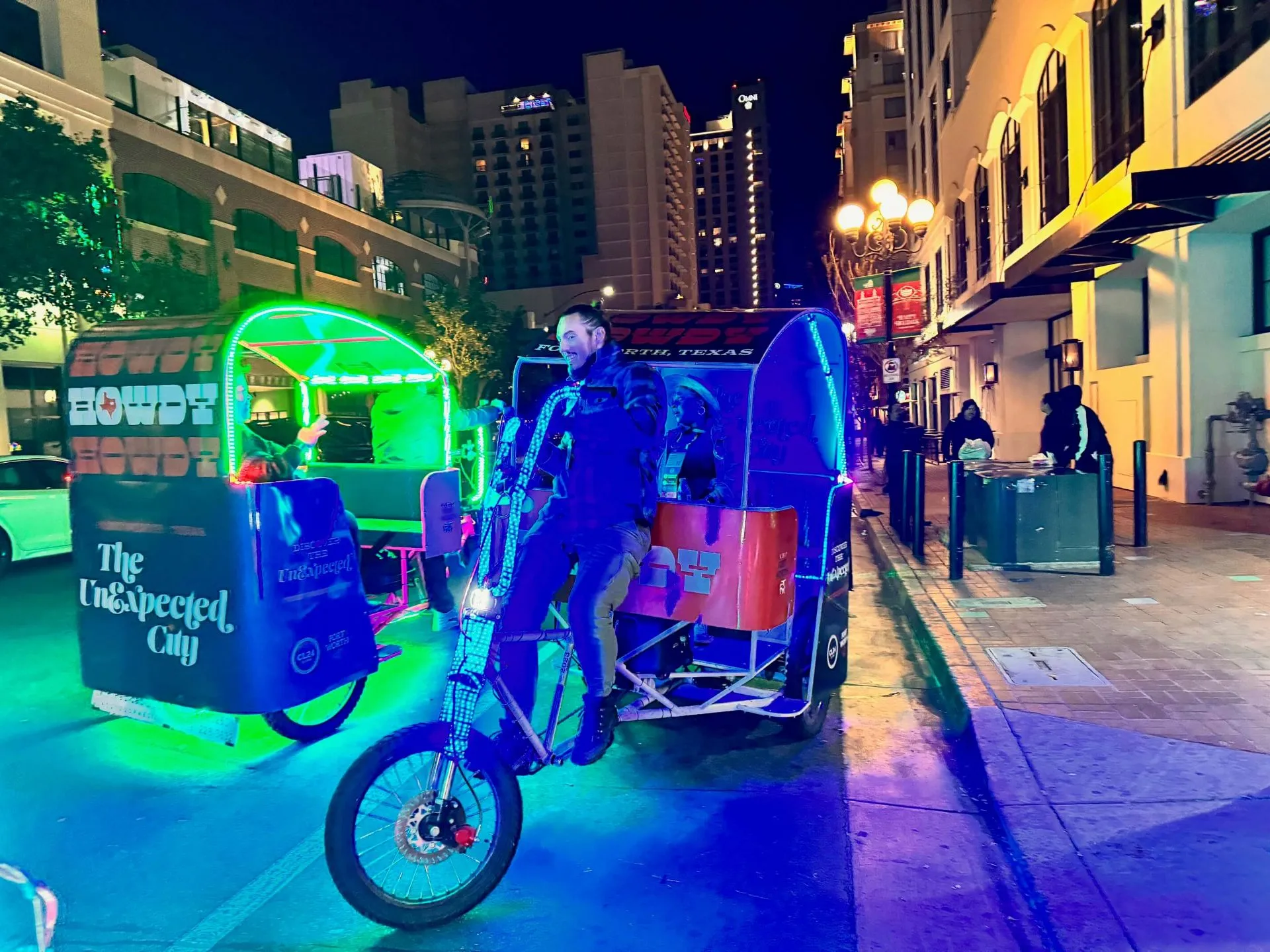 Visit Fort Worth pedicabs with neon lights in Gaslamp Quarter at night