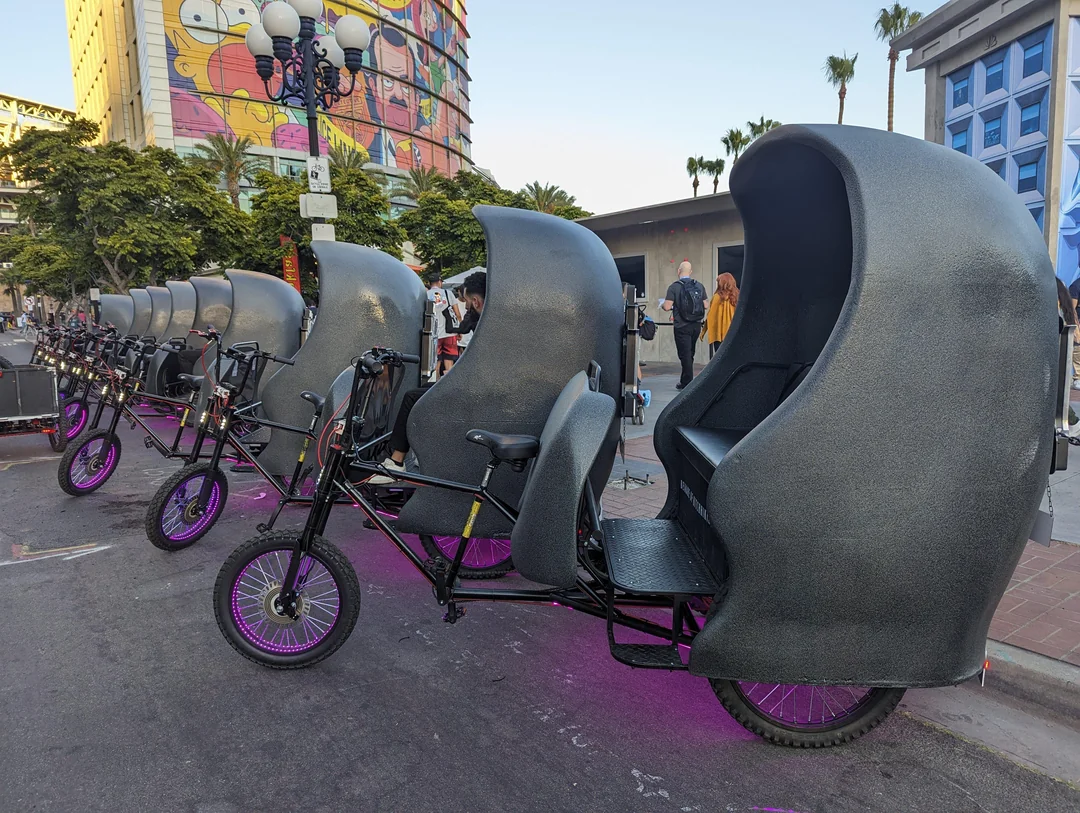 Row of illuminated Haunted Mansion Doom Buggy pedicabs at night during SDCC activation