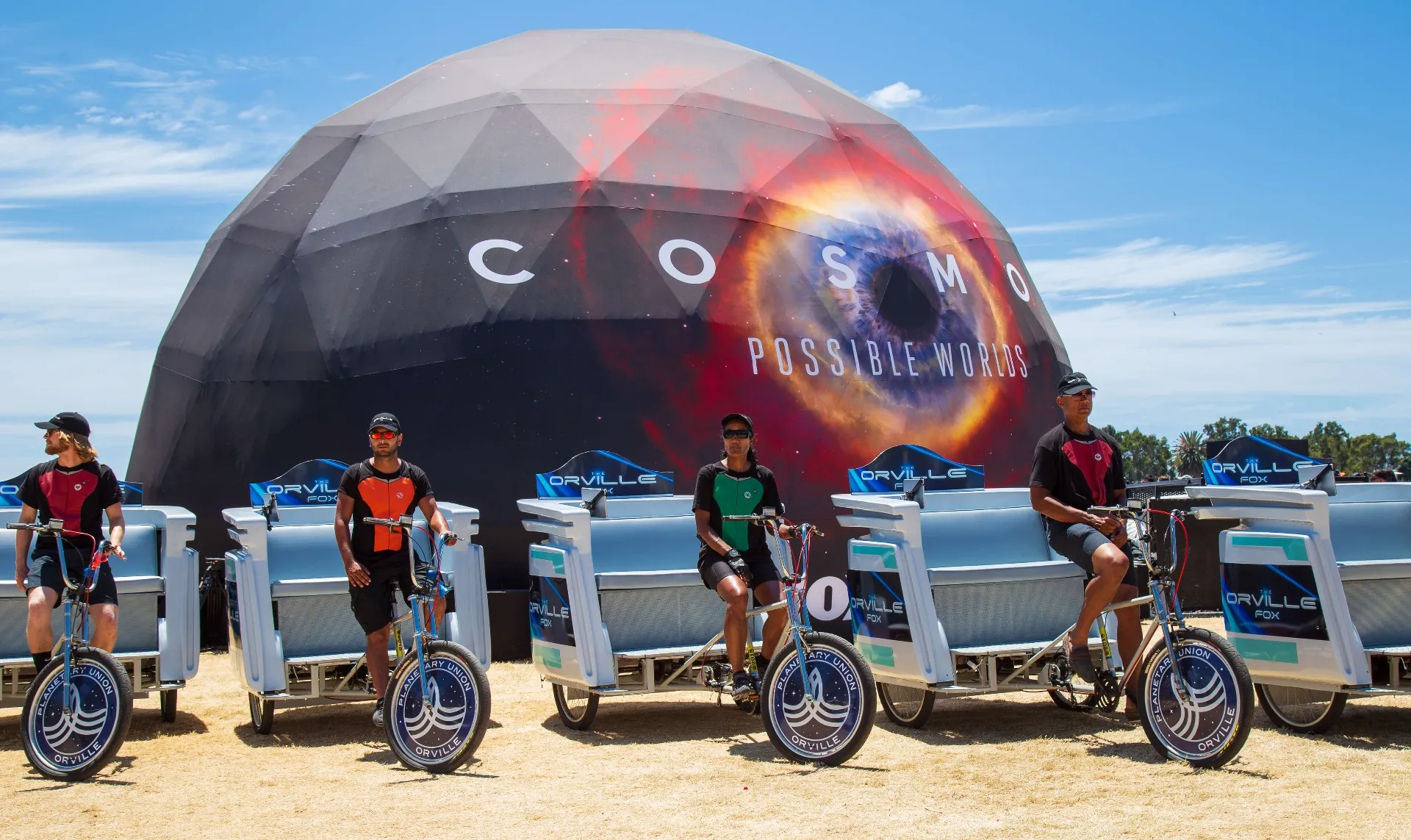 Orville pedicab fleet lined up in front of COSMOS Possible Worlds dome installation