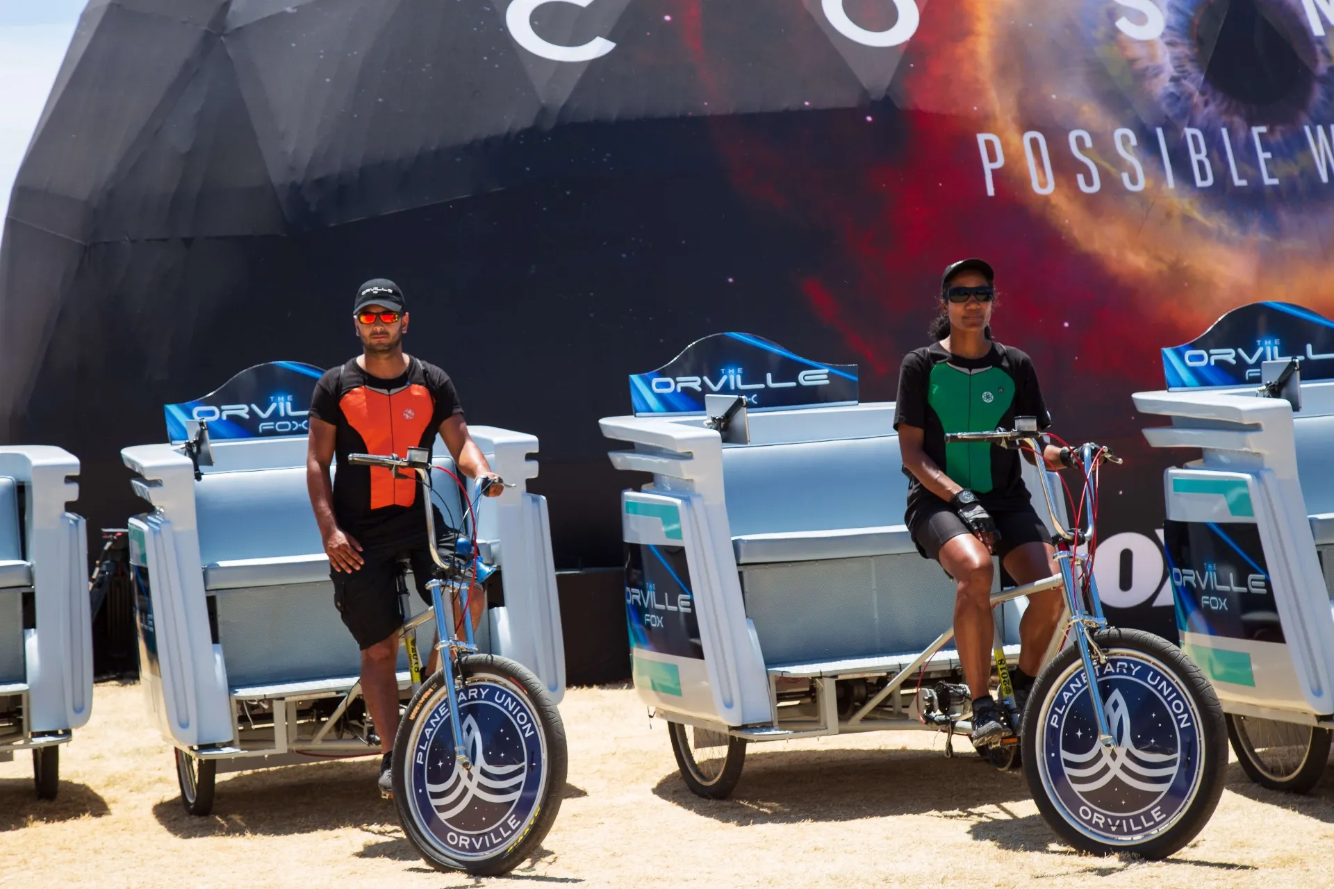 Close-up of Orville campaign pedicabs and riders at COSMOS event