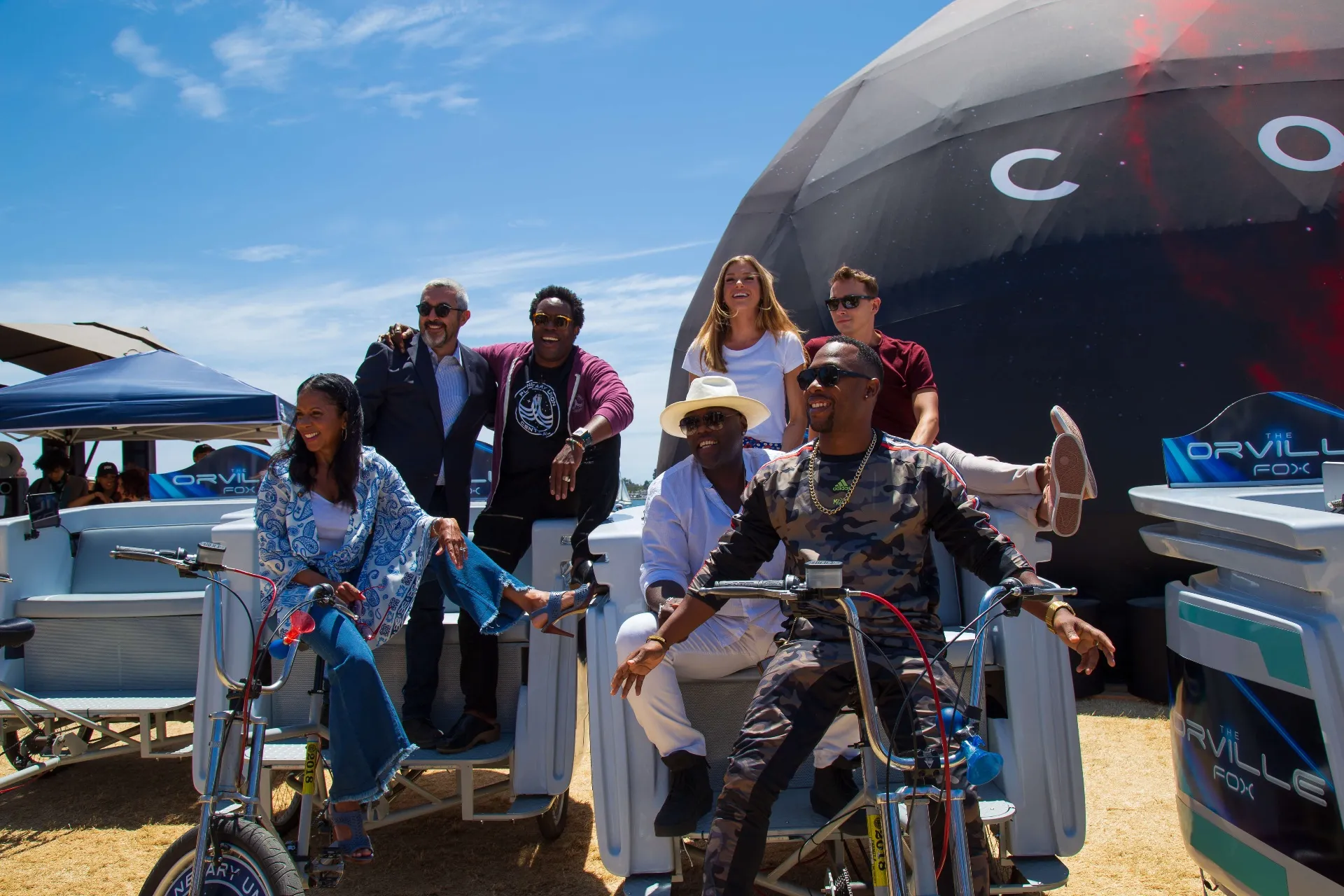 Orville cast posing on branded pedicabs at COSMOS activation Comic-Con