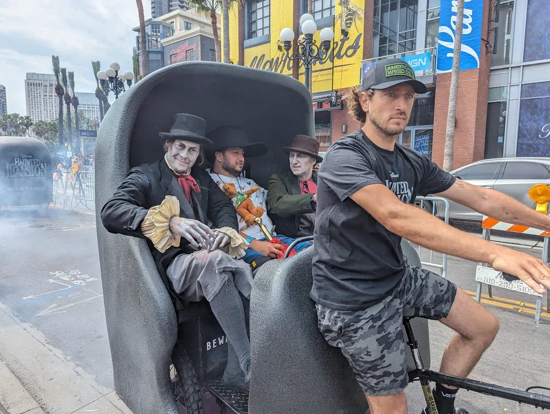 Haunted Mansion Doom Buggy pedicab with a costumed Hitchhiking Ghost at Comic-Con